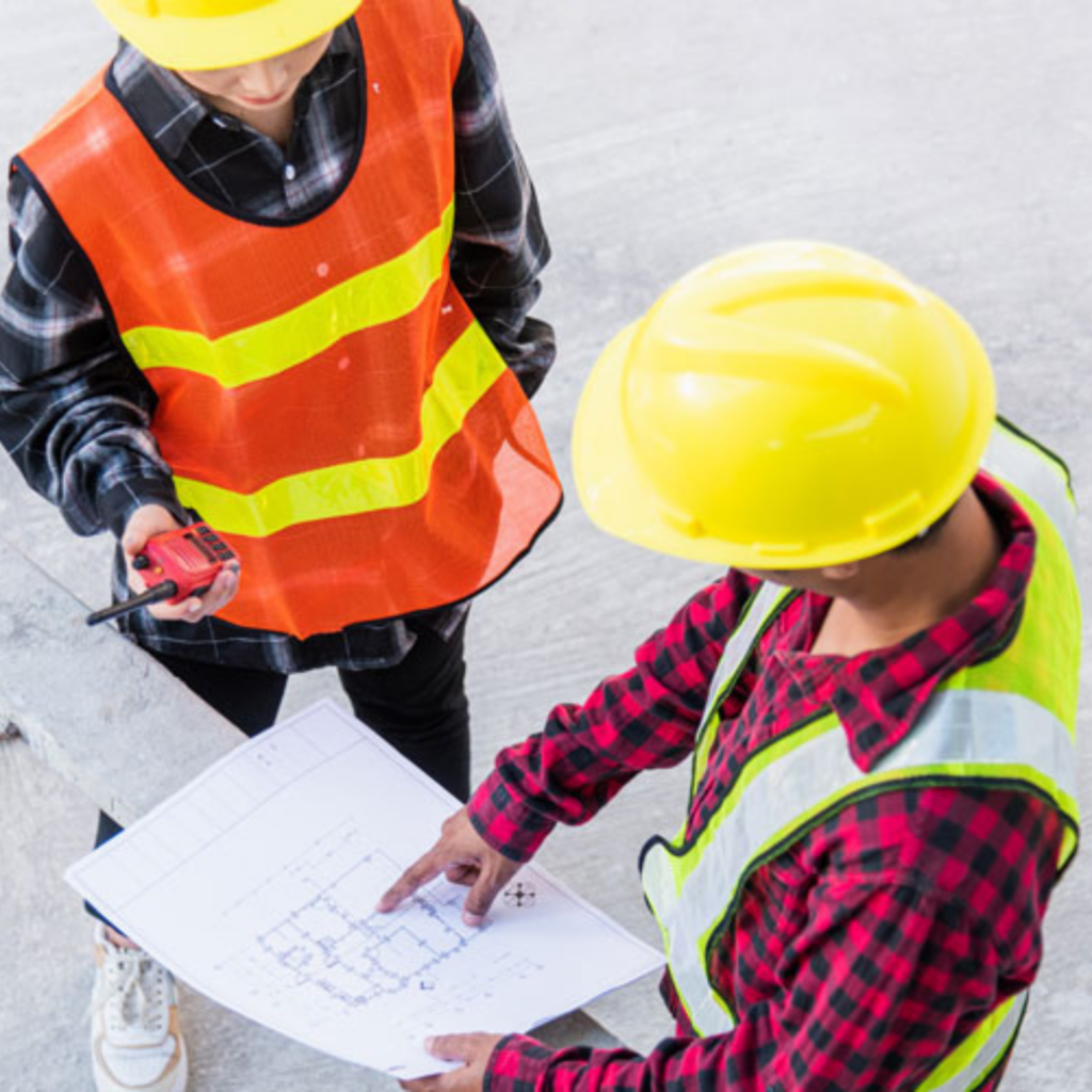 Due tecnici in cantiere che esaminano una piantina, servizio di rilievi offerto da GSG Air Conditioned srl